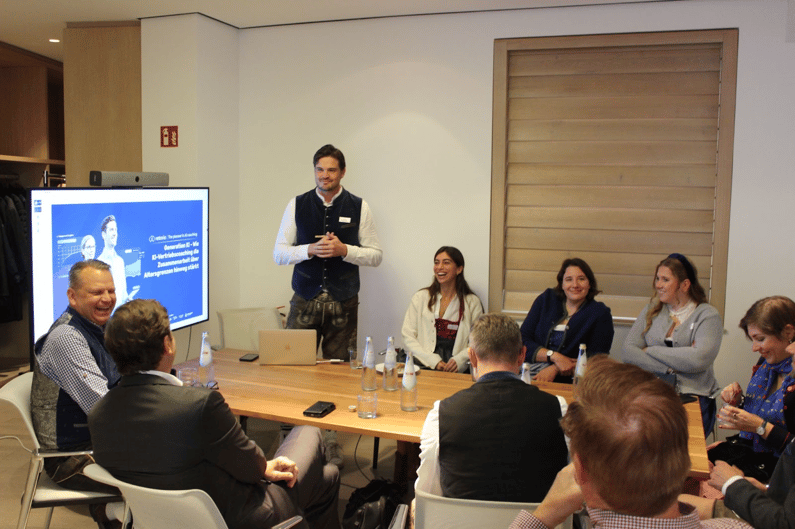Man giving a presentation to a small group in a meeting room.
