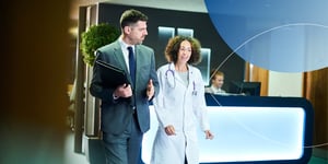 A sales representative and oncology doctor walking on the hospital lobby