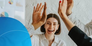 Woman with short hair laughing and giving high fives to other hands