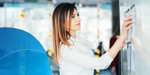 woman writing on board with office background 
