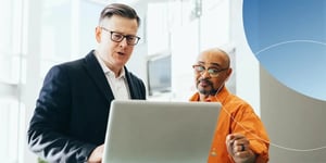 Retorio 2 men standing and looking at a laptop screen