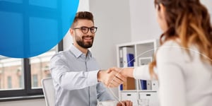 Man shaking hand with woman and smiling 