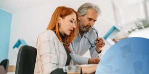 Male and female employee looking into laptop screen 