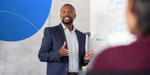 Man standing next to white board explaining