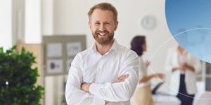 Man in white shirt with arms crossed smiling at camera 