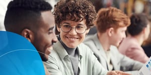 A woman sitting talking to a man smiling