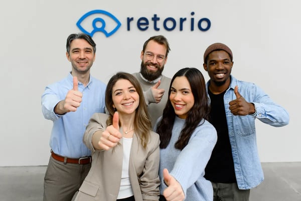 Retorio five people smiling at the camera with their thumbs up